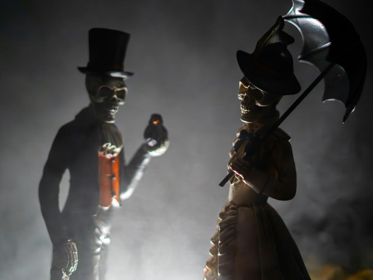 Skeleton figurines clothed in Victoria outfits.