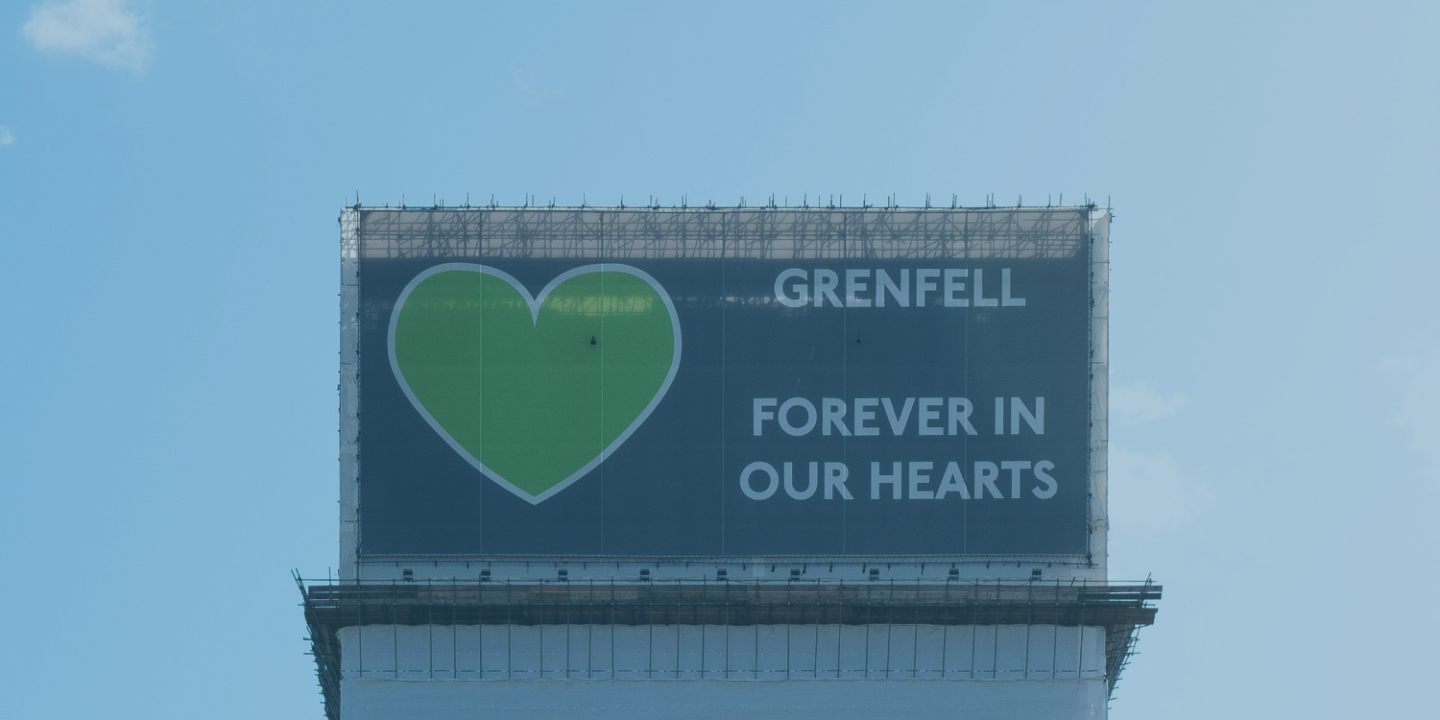 Grenfell Tower, wrapped in a protective layer bearing the legend: Grenfell forever in our hearts