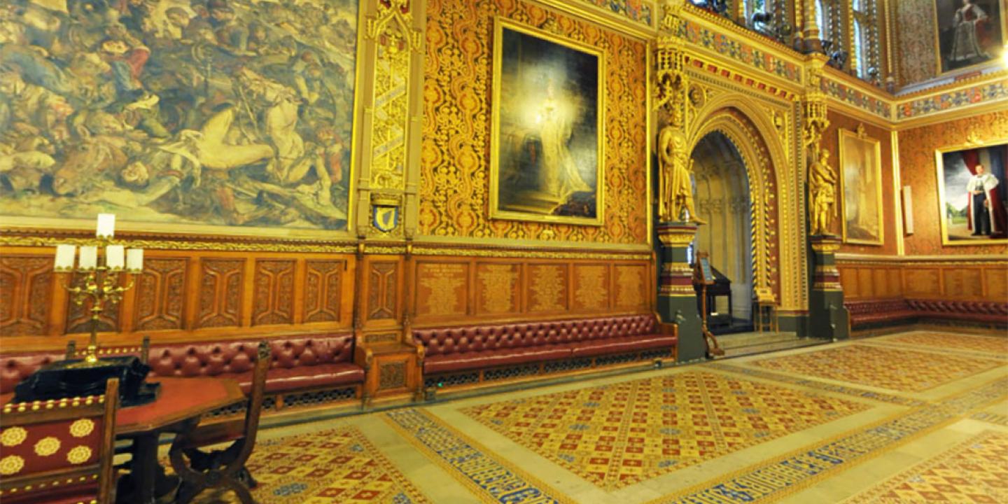 A grand highly dercorated hall in the neo-gothic style, with encaustic tiles in the foreground.