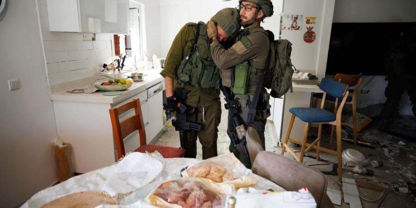 Two soliders console each other as they search a house that has been ransacked.