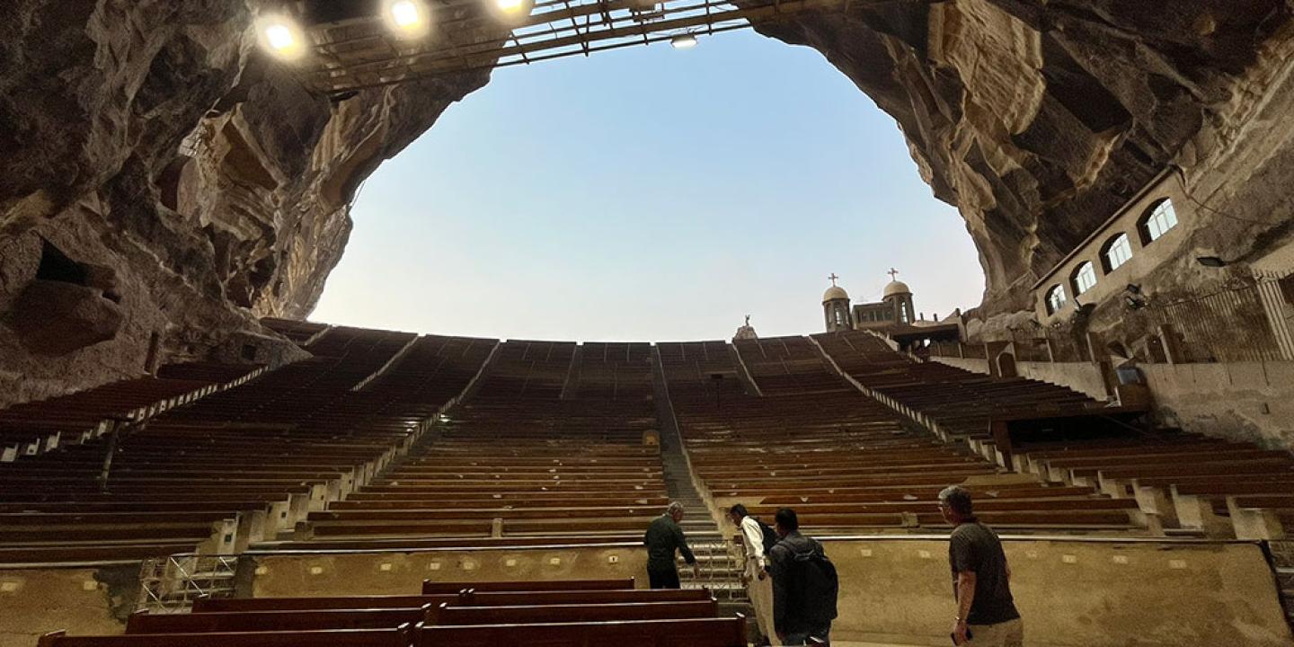 a view from the bottom of a huge cave to the sky, up row upon row of seating tiers.