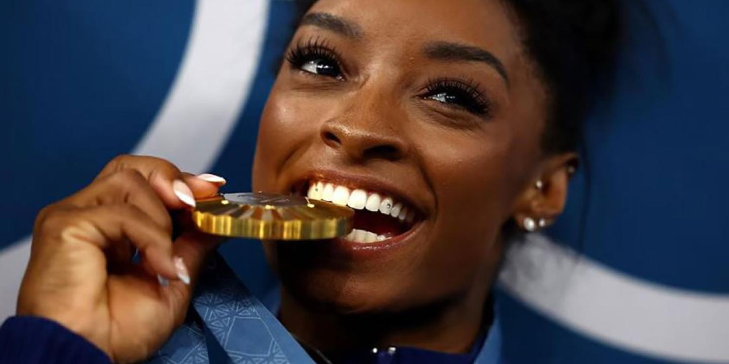 A gold medallist bites her medal.