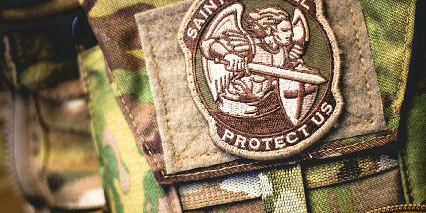 A patch depicting a angel in armour, wielding a sword, on camoflague uniform.
