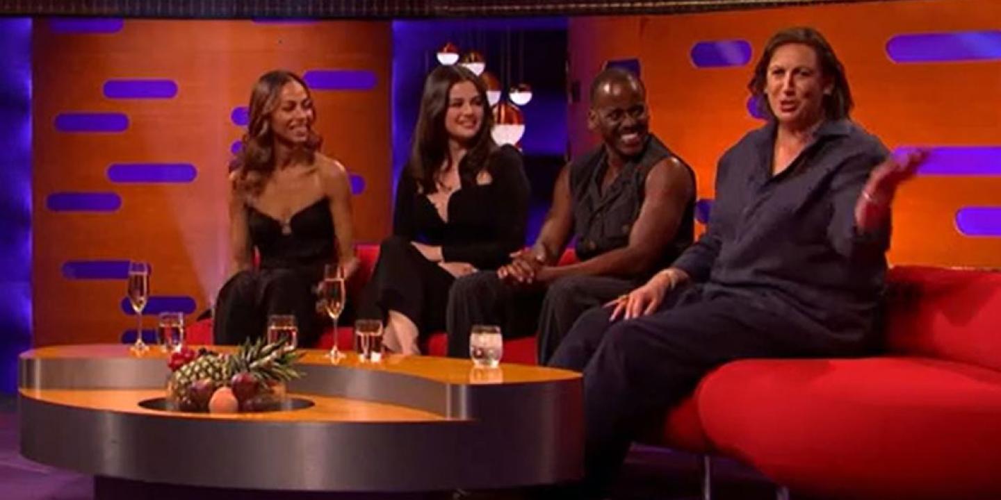 On a TV chat show, guests look to one of their own talking to the audience. 