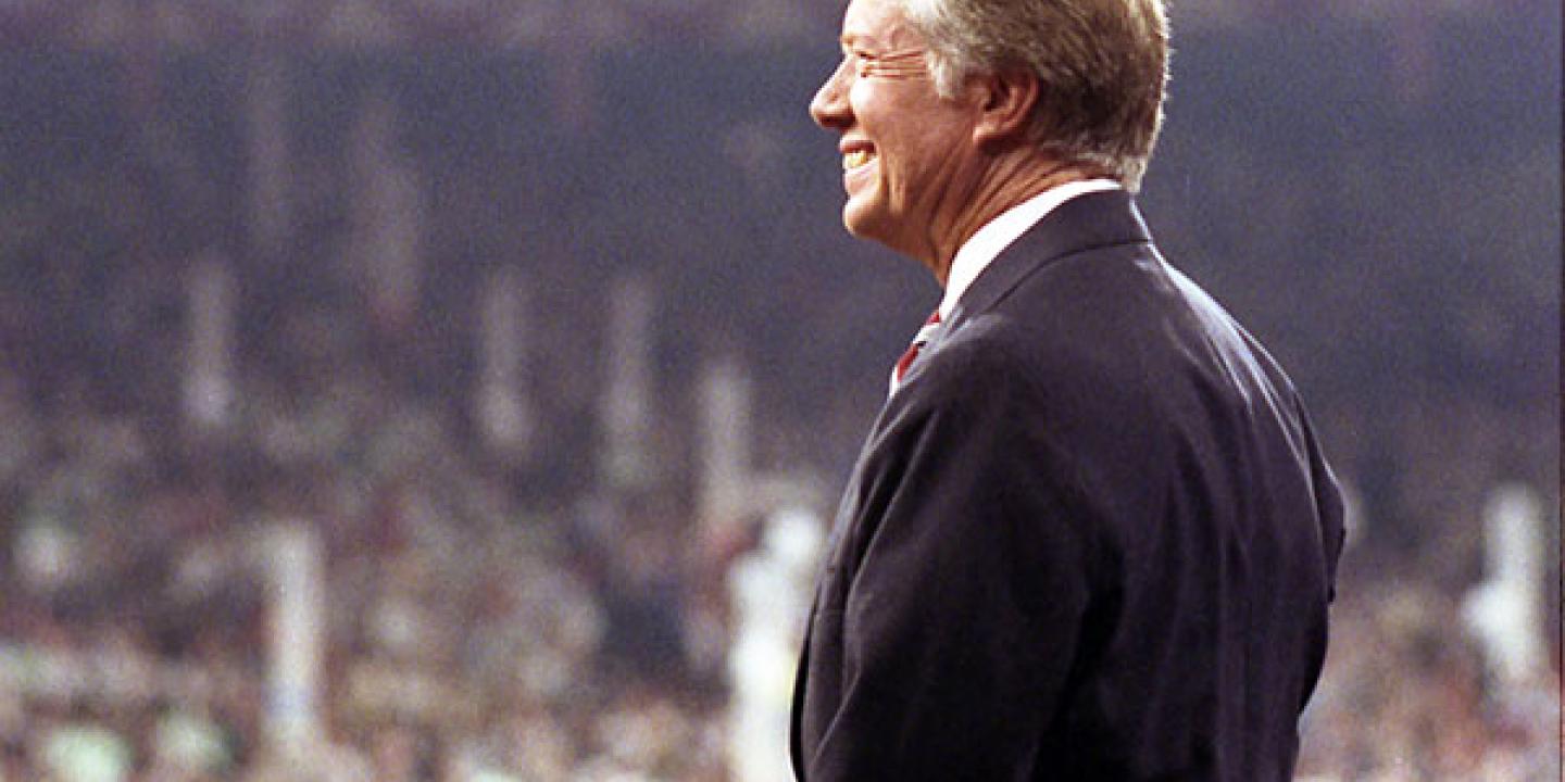 Jimmy Cater stands on a convention stage looking out over the crowd.