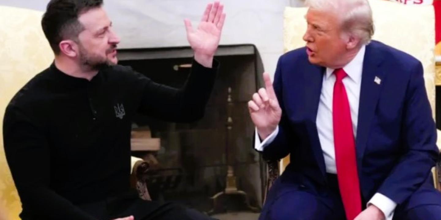 President Zelensky raises a hand while President Trump talks at him.