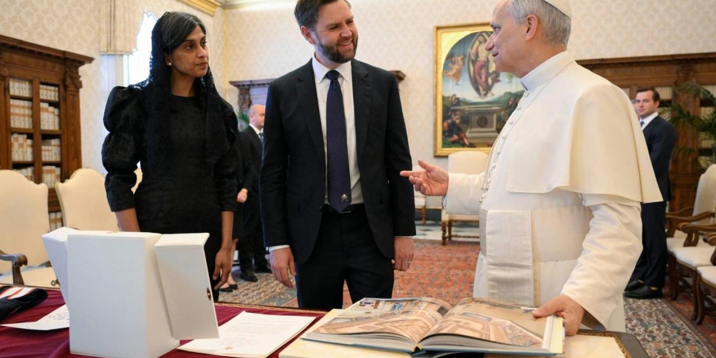 A VIP couple stand and talk with the Pope.