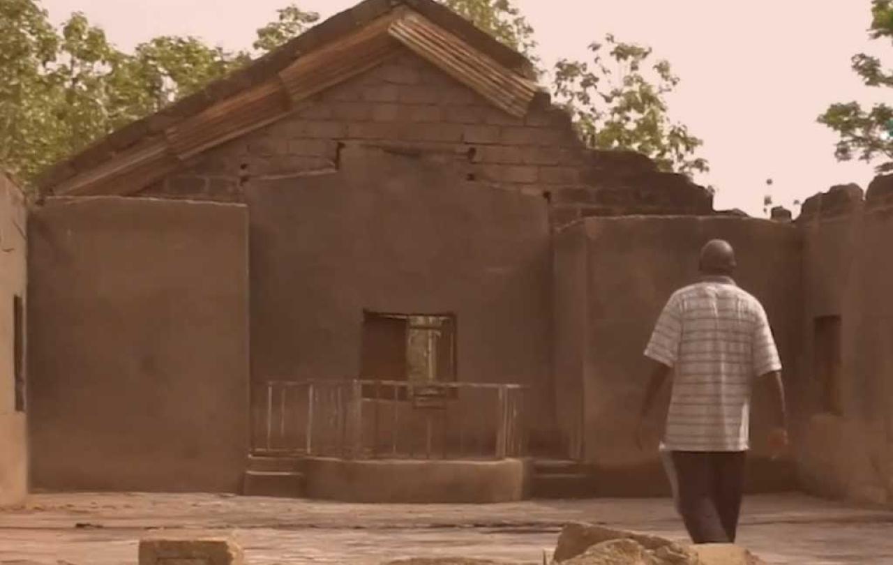 A person stands in the burn out shell of a church in Nigeria.