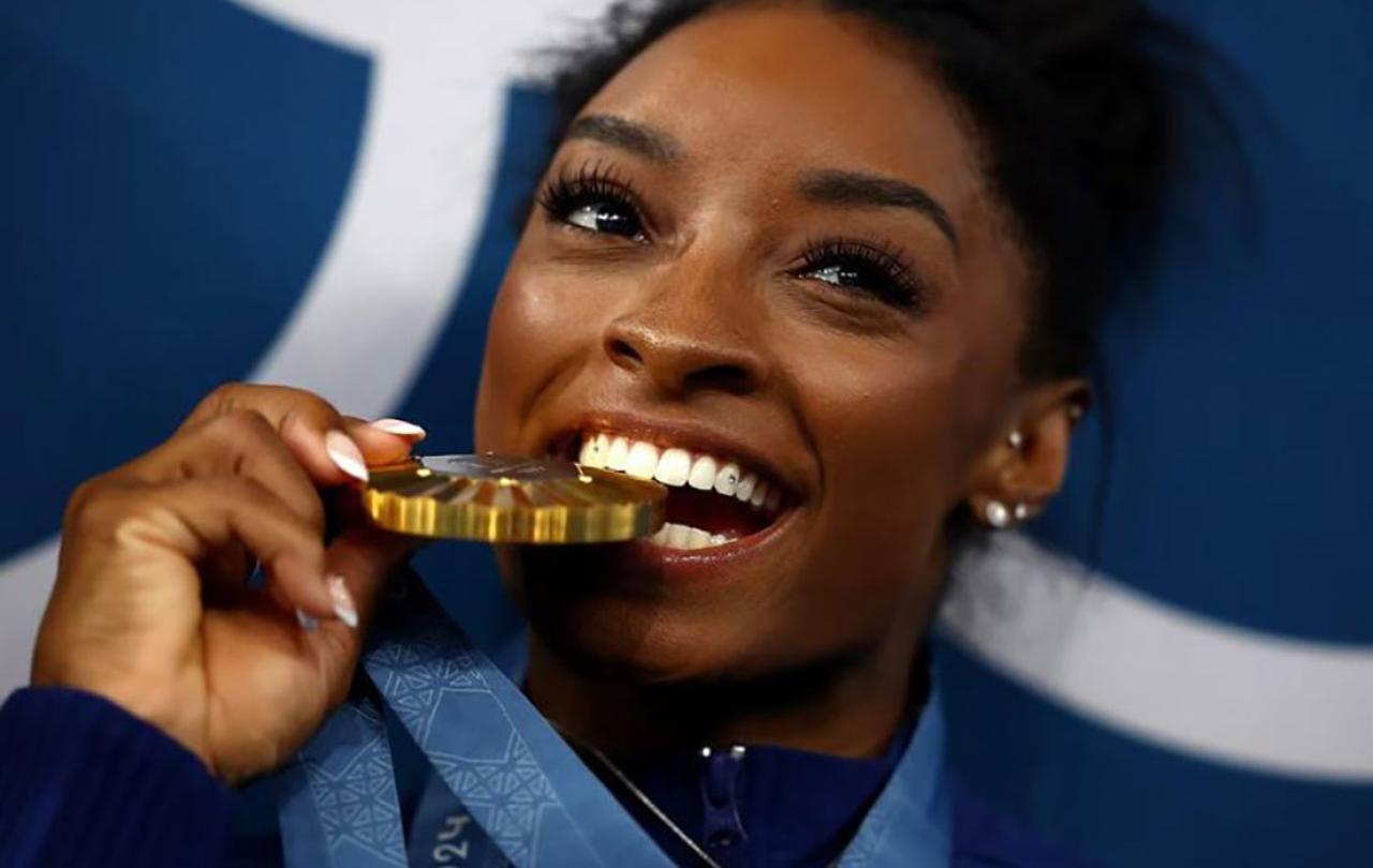 A gold medallist bites her medal.