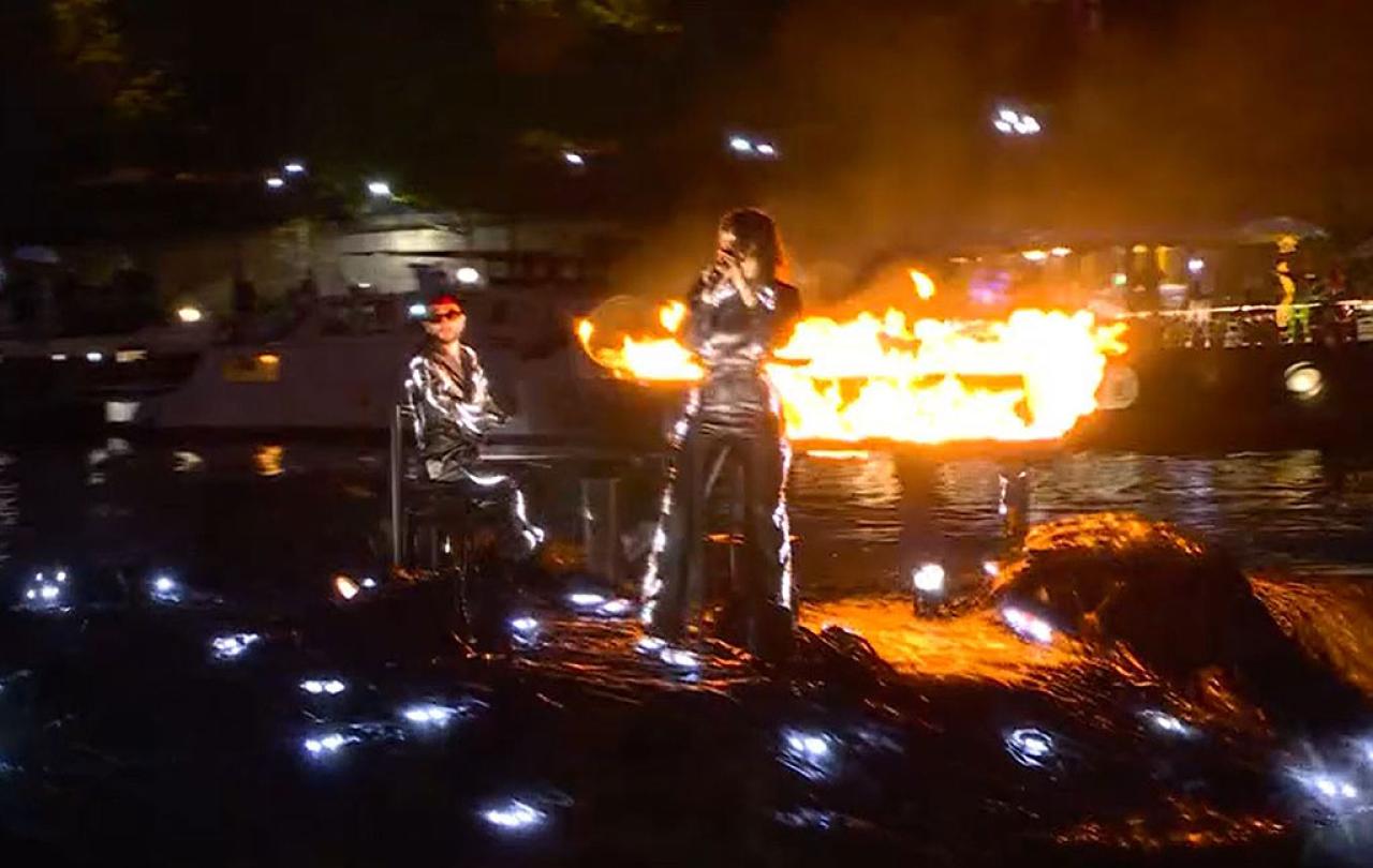 A floating stage bears a flaming piano and singer standing at a mic.