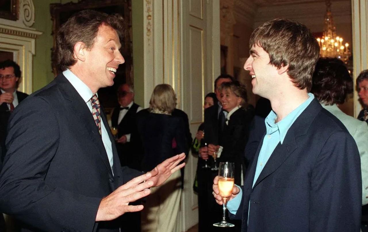 Tony Blair talks to a member of Oasis at a reception.