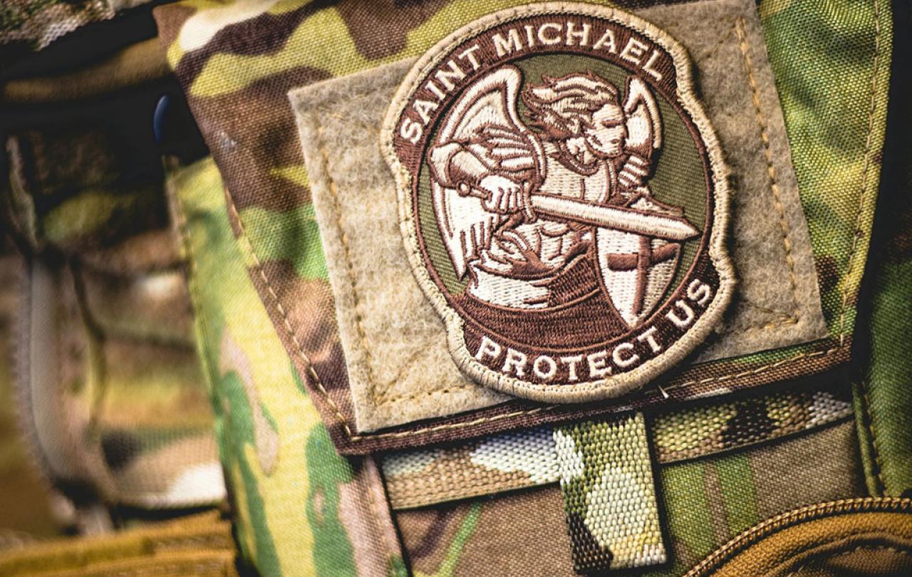 A patch depicting a angel in armour, wielding a sword, on camoflague uniform.