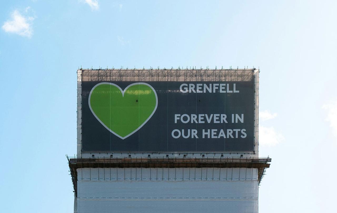 A wrapping around the Grenfell Tower bears a giant green heart.