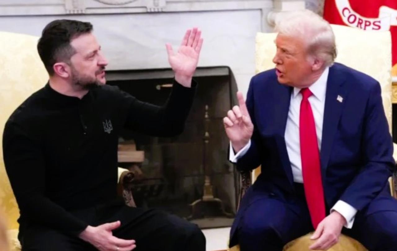 President Zelensky raises a hand while President Trump talks at him.