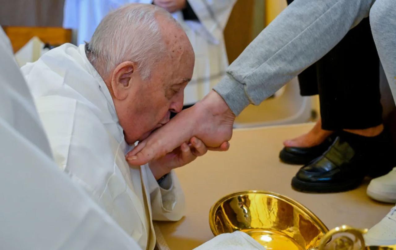 The Pope kisses a foot he has just washed.
