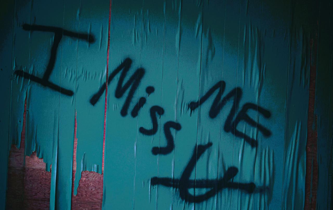 Graffiti reads 'I miss me' with u crossed out under the 'mem'