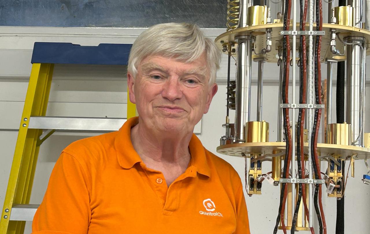 A professor stands next to experimental equipment.