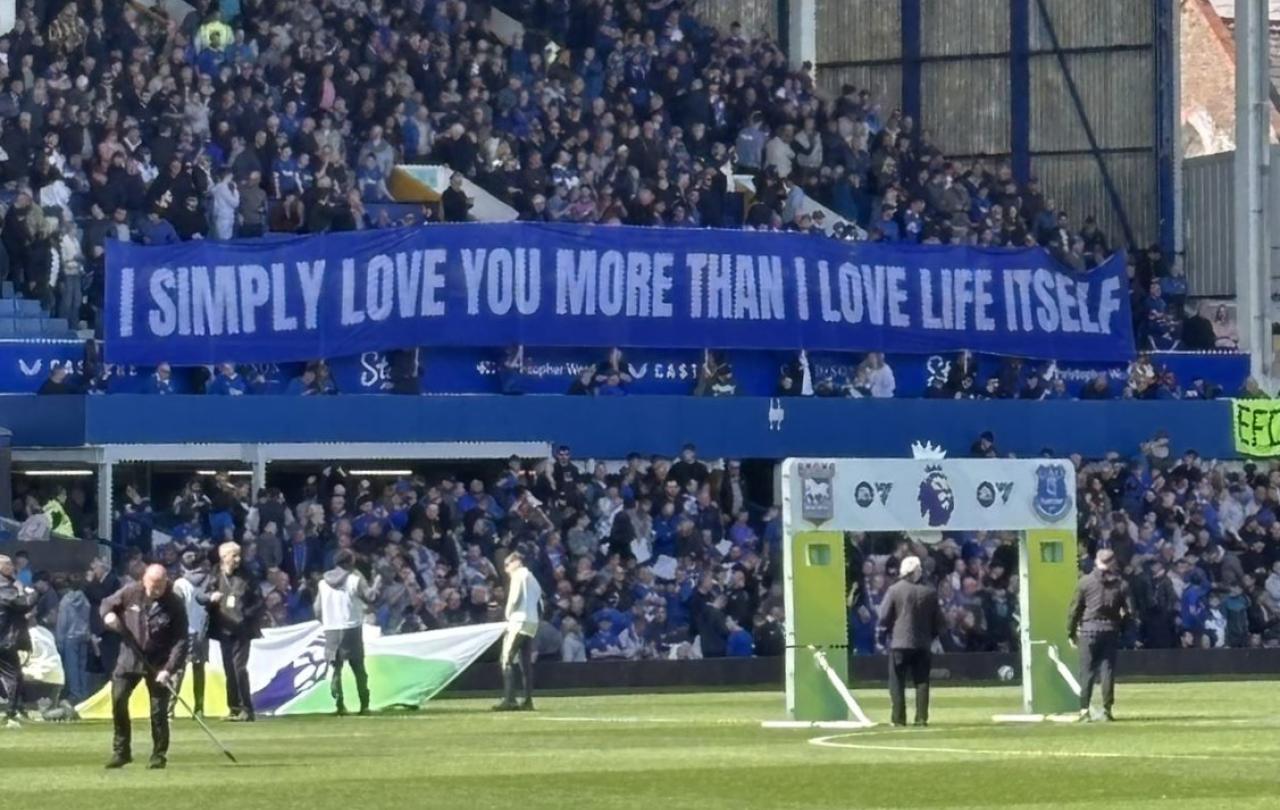A football stand displays a long banner with text on it.