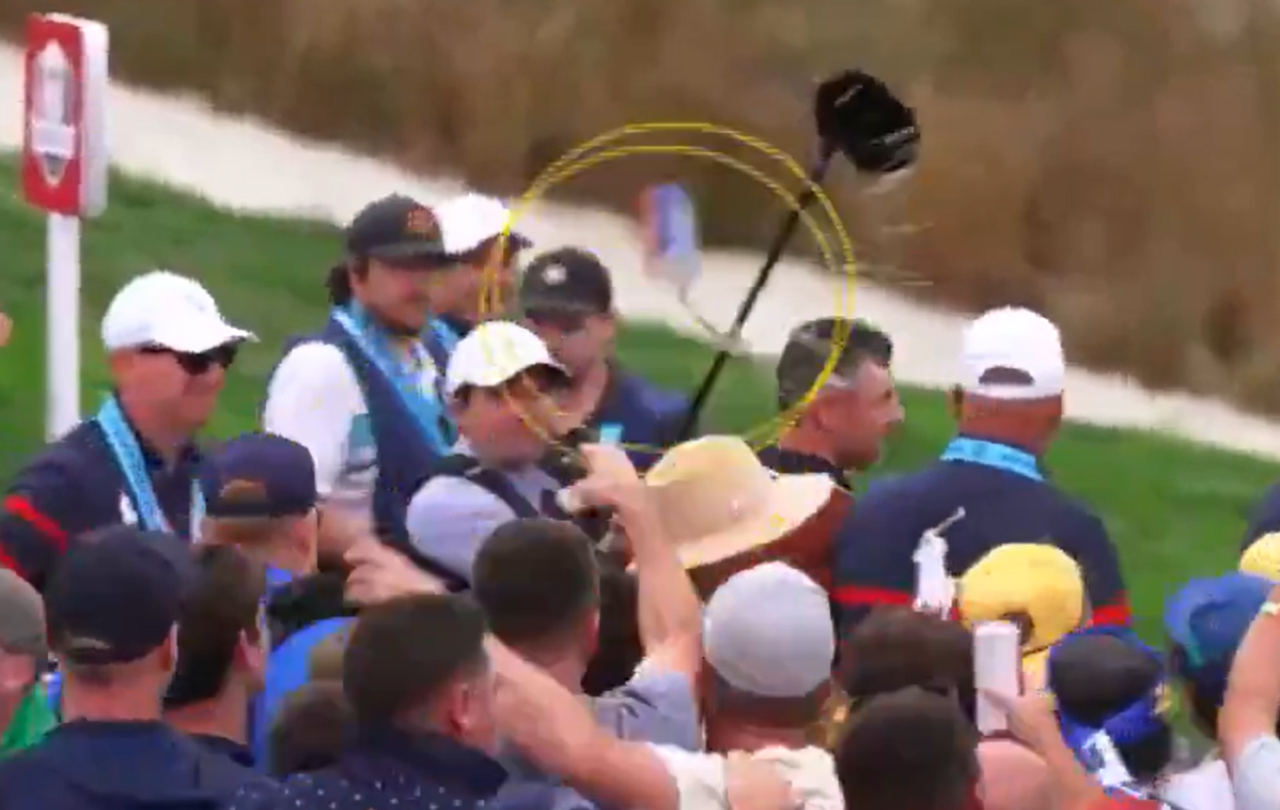 A video still shows a beer can thrown at a golf amid a crows