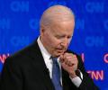 Joe Biden holds a fist to his chest as he stands and speaks.