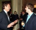 Tony Blair talks to a member of Oasis at a reception.