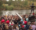 A crowd of teenagers gather by a Peter Pan statue to mourn a dead pop star