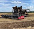 A soot stained burnt-out harvester sits in a recently harvested field.