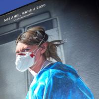 A gable end mural depicts a nurse in scrubs and a mask turning and looking towards the viewer.