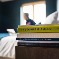 A pile of books on a bedside table.